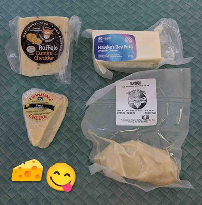 A photo of four cheeses. Buffalo cumin cheddar, Hawke's Bay feta, Evansdale brie, and Wairiri Buffalo scamorza