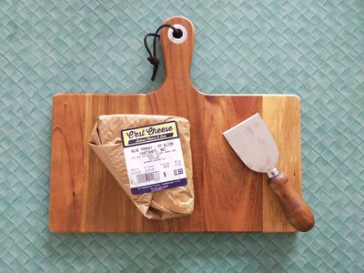 A photo of wrapped blue monkey cheese on a cheeseboard