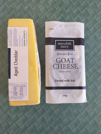 Photo of some aged cheddar and goat cheese which is dusted in ash