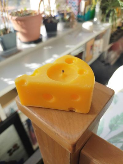 Photo of a cute palm-sized candle that looks like yellow swiss cheese