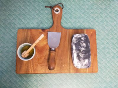 A photo of the now unwrapped goat cheese, which is covered with black ash.