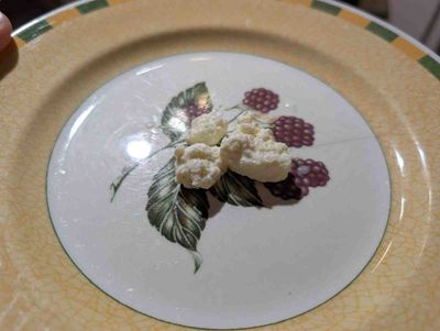 Photo of raw, lumpy ricotta on a plate