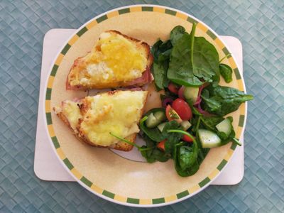 Photo of a nicely laid out croque monsieur and salad on a plate