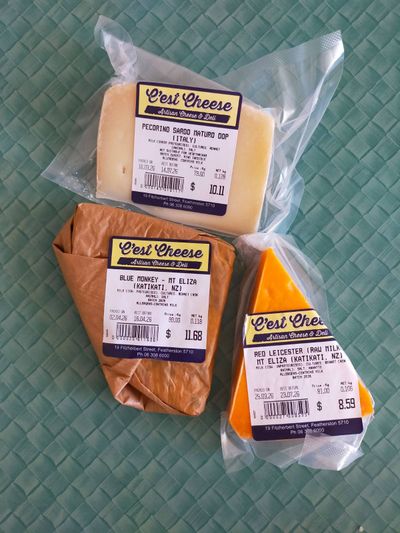 A photo of three cheeses: red leicester, blue monkey, and pecorino