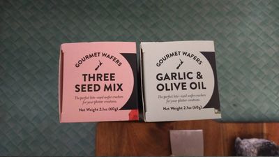 A photo of two packets of nice crackers: three seed mix and garlic & olic oil flavours.