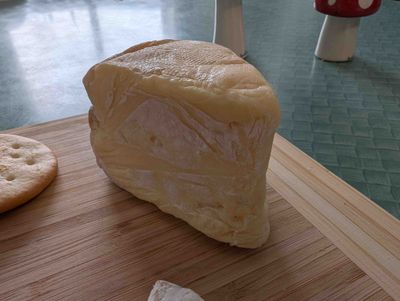 Close-up photo of the smoked brie. There are some white streaks where the healthy mold is