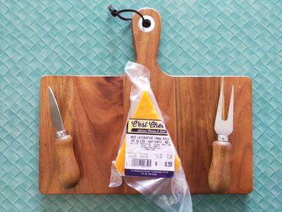 A photo of wrapped red leicester on a cheese board